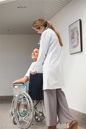 simsearch:6109-06195982,k - Patient sitting on a wheelchair looking at a doctor in hospital ward Fotografie stock - Microstock e Abbonamento, Codice: 400-06734684