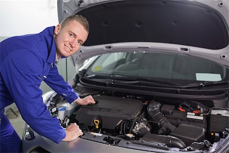 Smiling mechanic looking at camera in a garage Stock Photo - Budget Royalty-Free & Subscription, Code: 400-06734698