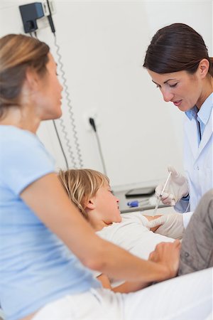 simsearch:400-06734647,k - Serious doctor giving child an injection in examination room Stock Photo - Budget Royalty-Free & Subscription, Code: 400-06734743