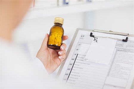 simsearch:400-04130714,k - Pharmacist holding a drug bottle and a clipboard in hospital Photographie de stock - Aubaine LD & Abonnement, Code: 400-06734798