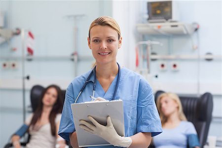 simsearch:400-06734658,k - Nurse writing on a clipboard next to patients in hospital ward Stock Photo - Budget Royalty-Free & Subscription, Code: 400-06734839