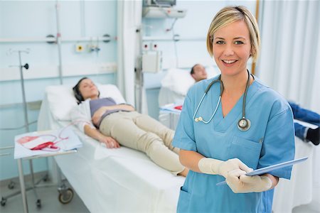 simsearch:400-06734658,k - Smiling nurse next to transfused patients in hospital ward Stock Photo - Budget Royalty-Free & Subscription, Code: 400-06734884