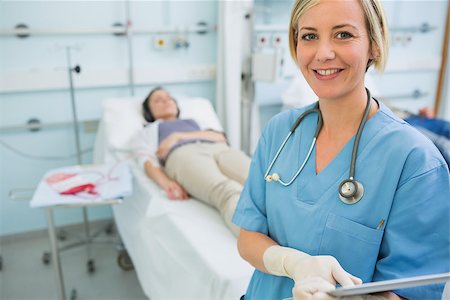 simsearch:400-06734658,k - Smiling nurse standing next to transfused patients in hospital ward Stock Photo - Budget Royalty-Free & Subscription, Code: 400-06734886