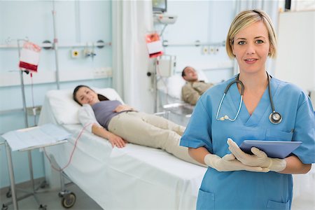 simsearch:400-06734658,k - Nurse next to patients holding a clipboard in hospital ward Stock Photo - Budget Royalty-Free & Subscription, Code: 400-06734981