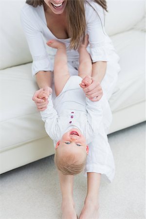 simsearch:400-08320108,k - Mother sitting on a sofa playing with a baby in living room Foto de stock - Royalty-Free Super Valor e Assinatura, Número: 400-06735049