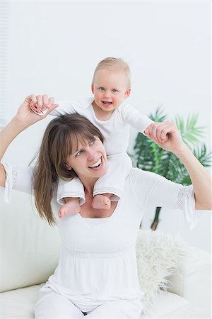 simsearch:400-08320108,k - Baby sitting on shoulders of his mother in living room Foto de stock - Royalty-Free Super Valor e Assinatura, Número: 400-06735084