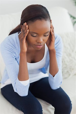 sad woman sitting alone on couch - Close up of a black woman holding her head in a living room Stock Photo - Budget Royalty-Free & Subscription, Code: 400-06735240