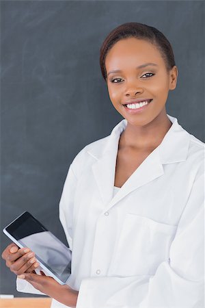 Teacher holding a tablet computer while looking at camera in a classroom Stock Photo - Budget Royalty-Free & Subscription, Code: 400-06735354
