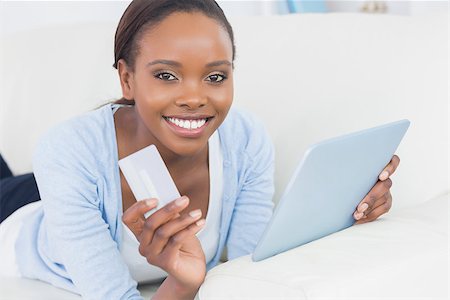 Black woman holding a tablet computer and a credit card in a living room Stock Photo - Budget Royalty-Free & Subscription, Code: 400-06735394