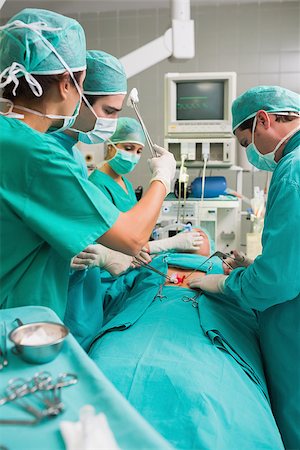 simsearch:400-06735487,k - Nurse mopping the brow of a surgeon in an operating theatre Fotografie stock - Microstock e Abbonamento, Codice: 400-06735475