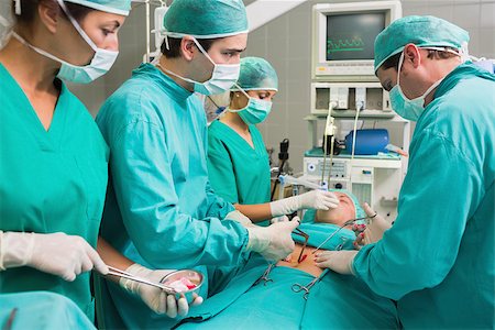 simsearch:400-06735487,k - Surgeon operating with surgical tools in an operating theatre Fotografie stock - Microstock e Abbonamento, Codice: 400-06735477