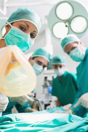 simsearch:400-06735487,k - Nurses and surgeons looking at camera in an operating theatre Fotografie stock - Microstock e Abbonamento, Codice: 400-06735489