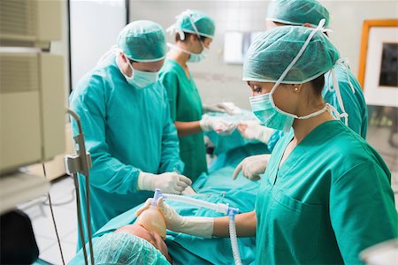 simsearch:400-06735487,k - View of a nurse holding an oxygen mask in an operating theatre Fotografie stock - Microstock e Abbonamento, Codice: 400-06735480