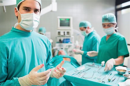 simsearch:400-06735487,k - Surgeon wearing gloves with blood in an operating theatre Fotografie stock - Microstock e Abbonamento, Codice: 400-06735482