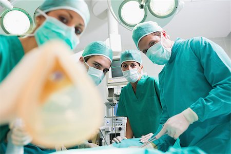 simsearch:400-06735487,k - Focus on a surgical team holding an anesthesia mask in an operating theatre Fotografie stock - Microstock e Abbonamento, Codice: 400-06735492