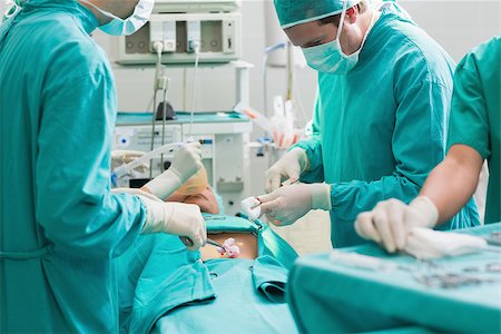 simsearch:400-06735487,k - Surgeon operating a patient in an operating theater in a hospital Fotografie stock - Microstock e Abbonamento, Codice: 400-06735546