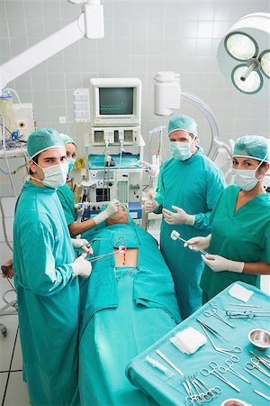 simsearch:400-06735487,k - Group of surgeons operating a patient in an operating theater in a hospital Fotografie stock - Microstock e Abbonamento, Codice: 400-06735556