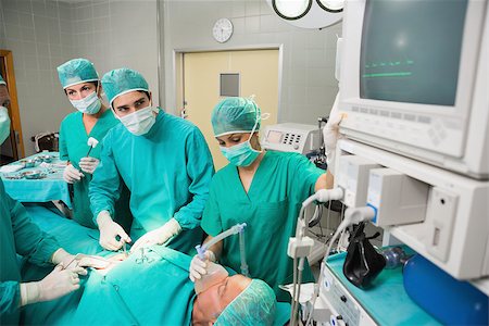 simsearch:400-06735487,k - Concentrated surgeon looking at a monitor in an operating theatre Fotografie stock - Microstock e Abbonamento, Codice: 400-06735585