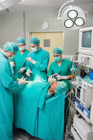 simsearch:400-06735487,k - View of a surgical team operating in an operating theatre Fotografie stock - Microstock e Abbonamento, Codice: 400-06735580