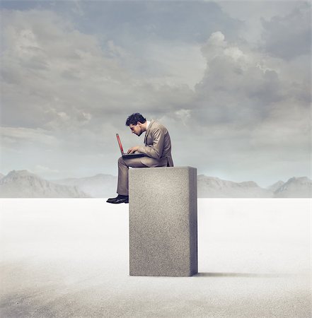 Businessman using a laptop on a concrete block in a desert Photographie de stock - Aubaine LD & Abonnement, Code: 400-06735882