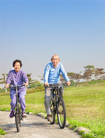 Happy asian seniors couple biking in the park Stock Photo - Budget Royalty-Free & Subscription, Code: 400-06736441