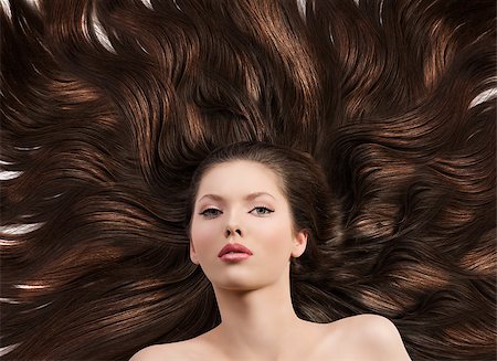 simsearch:400-06790945,k - pretty brunette lying on her long brown hair laying down, her face is in front of the camera and she looks in to the lens Photographie de stock - Aubaine LD & Abonnement, Code: 400-06738054