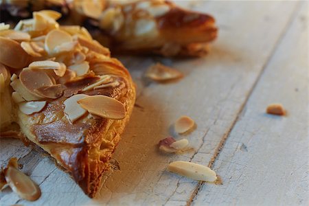 Fresh berry and almond pinwheel pastry, sprinkled with icing sugar on a brown wooden serving board with copy space - Shallow Depth of Field (DOF) Stock Photo - Budget Royalty-Free & Subscription, Code: 400-06739265