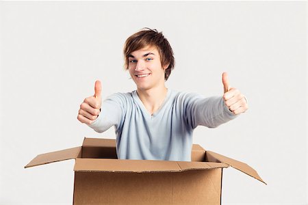 Portrait of a handsome young man a cardbox with thumbs up Stock Photo - Budget Royalty-Free & Subscription, Code: 400-06739932