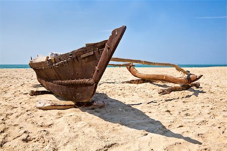 Landscape of a Goan secluded beach with shoreline, horizon and a fisherman single hull outrigger catamaran loaded with his working tools and tackle Stock Photo - Budget Royalty-Free & Subscription, Code: 400-06733456