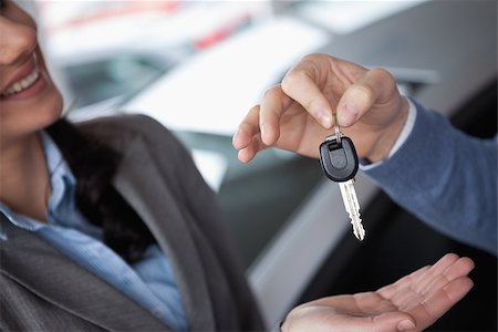 Smiling woman receiving keys from someone in a car shop Stock Photo - Budget Royalty-Free & Subscription, Code: 400-06733574