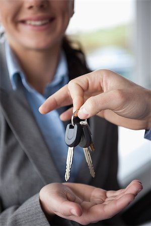 Hand holding keys over the hand of a woman in a car shop Stock Photo - Budget Royalty-Free & Subscription, Code: 400-06733575