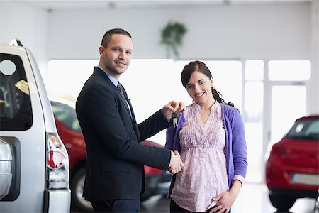 Salesman shaking hand and giving keys to a woman in a car shop Stock Photo - Budget Royalty-Free & Subscription, Code: 400-06733578