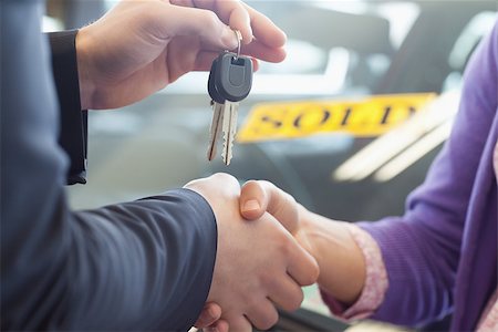 Person shaking hands in front of a sold car in a car shop Stock Photo - Budget Royalty-Free & Subscription, Code: 400-06733579