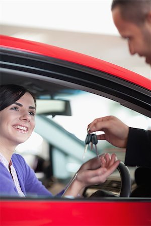 Woman smiling while receiving car keys in a car shop Stock Photo - Budget Royalty-Free & Subscription, Code: 400-06733683