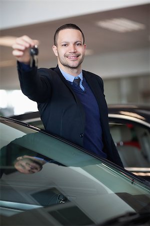 Dealer holding car keys in a dealership Stock Photo - Budget Royalty-Free & Subscription, Code: 400-06733714