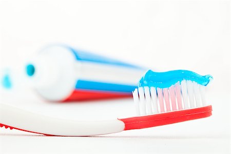 Tube of toothpaste next to a red toothbrush against white background Stock Photo - Budget Royalty-Free & Subscription, Code: 400-06733794