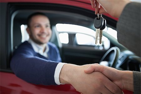 Woman giving car keys while shaking hand in a dealership Stock Photo - Budget Royalty-Free & Subscription, Code: 400-06733885