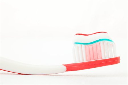 Toothpaste on a red toothbrush against white background Stock Photo - Budget Royalty-Free & Subscription, Code: 400-06733932