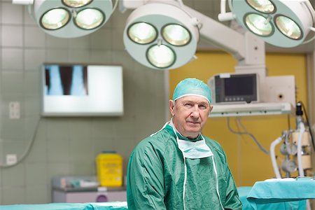 simsearch:400-06734621,k - Sedate surgeon looking at camera in an operating theatre Stock Photo - Budget Royalty-Free & Subscription, Code: 400-06733960