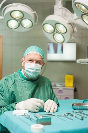 simsearch:400-06734621,k - Surgeon sitting in front of surgical tools in a surgical room Stock Photo - Budget Royalty-Free & Subscription, Code: 400-06733974