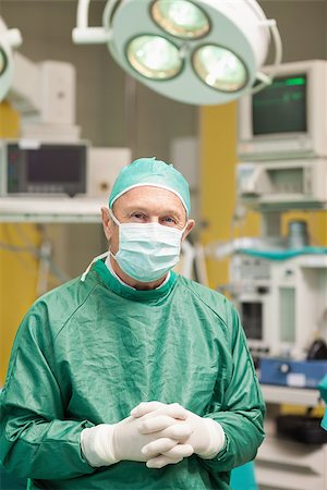 simsearch:400-06734621,k - Surgeon smiling while crossing his hands in a surgical room Stock Photo - Budget Royalty-Free & Subscription, Code: 400-06733971