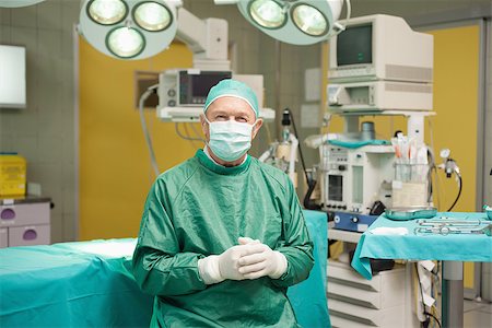 simsearch:400-06734621,k - Surgeon smiling while joining his hands together in a surgical room Stock Photo - Budget Royalty-Free & Subscription, Code: 400-06733972