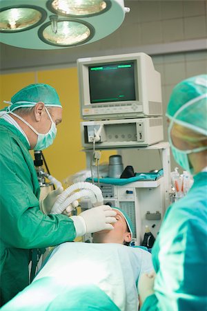 simsearch:400-06734621,k - Surgeon putting an oxygen mask on a patient in a surgical room Stock Photo - Budget Royalty-Free & Subscription, Code: 400-06733995