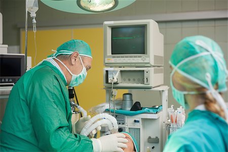 Surgeon holding a mask on the face of a patient in a surgical room Stock Photo - Budget Royalty-Free & Subscription, Code: 400-06733996