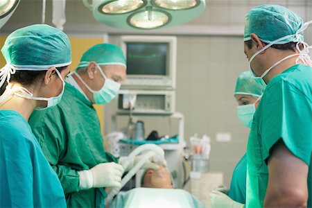 simsearch:400-06734621,k - Surgical team working together in a surgical room Stock Photo - Budget Royalty-Free & Subscription, Code: 400-06733997