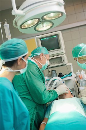 simsearch:400-06734621,k - Medical team operating in a surgical room Stock Photo - Budget Royalty-Free & Subscription, Code: 400-06733998