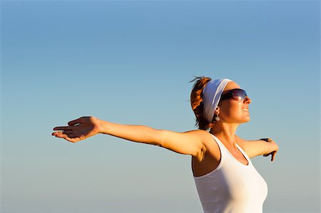 rozbyshaka (artist) - Smiling girl with arms raised towards the sky on sunny day on sunrise Stock Photo - Budget Royalty-Free & Subscription, Code: 400-06745187