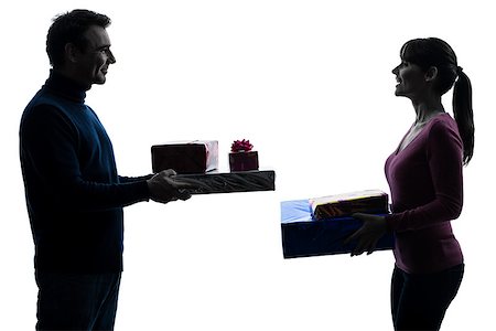 one caucasian couple woman man offering christmas  gifts in silhouette studio isolated on white background Stock Photo - Budget Royalty-Free & Subscription, Code: 400-06748257