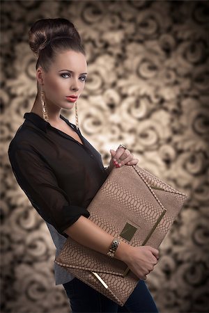 female model jeans photography - pretty brunette with dark shirt and bag, she is turned of three quarters at left and looks in to the lens Stock Photo - Budget Royalty-Free & Subscription, Code: 400-06740858