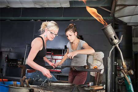 Worker helping woman clean iron tools at workbench Stock Photo - Budget Royalty-Free & Subscription, Code: 400-06741244